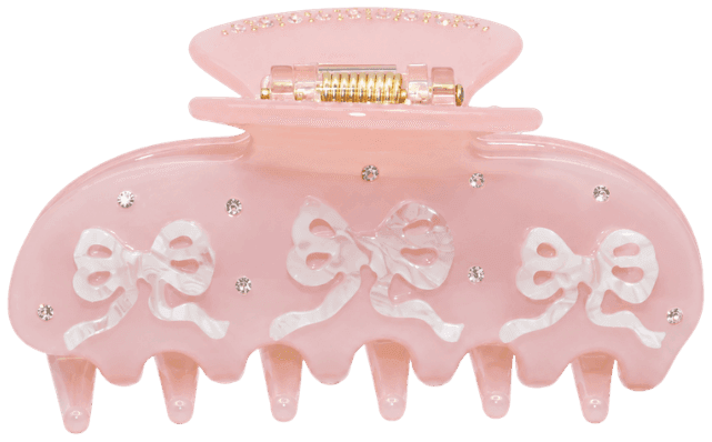 The Coquette claw clip in pale pink, with beaded bows along the jaw, straight on from the front.